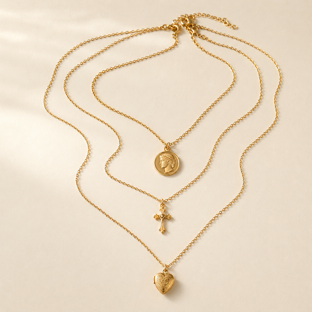 Layered gold pendant necklace trio with coin cross and heart locket