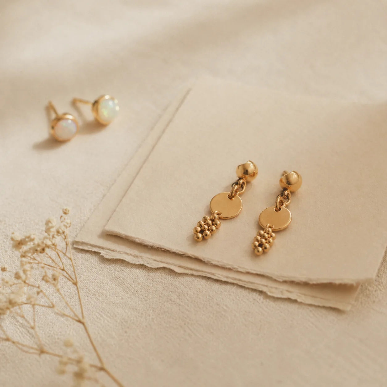 Gold earrings on ivory card